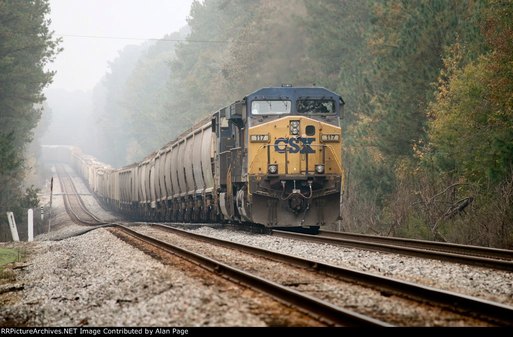 CSX 117 and 5465 wait for green with a line of covered hoppers